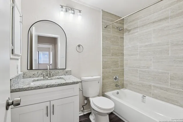 a bathroom with a granite countertop sink toilet and shower