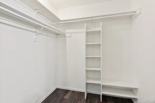 a view of walk in closet with empty racks