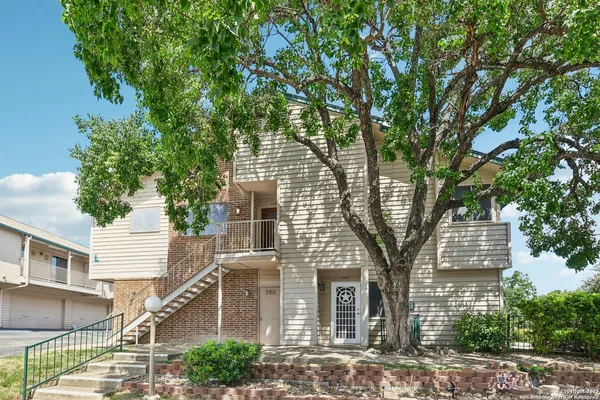 a front view of a house with a tree