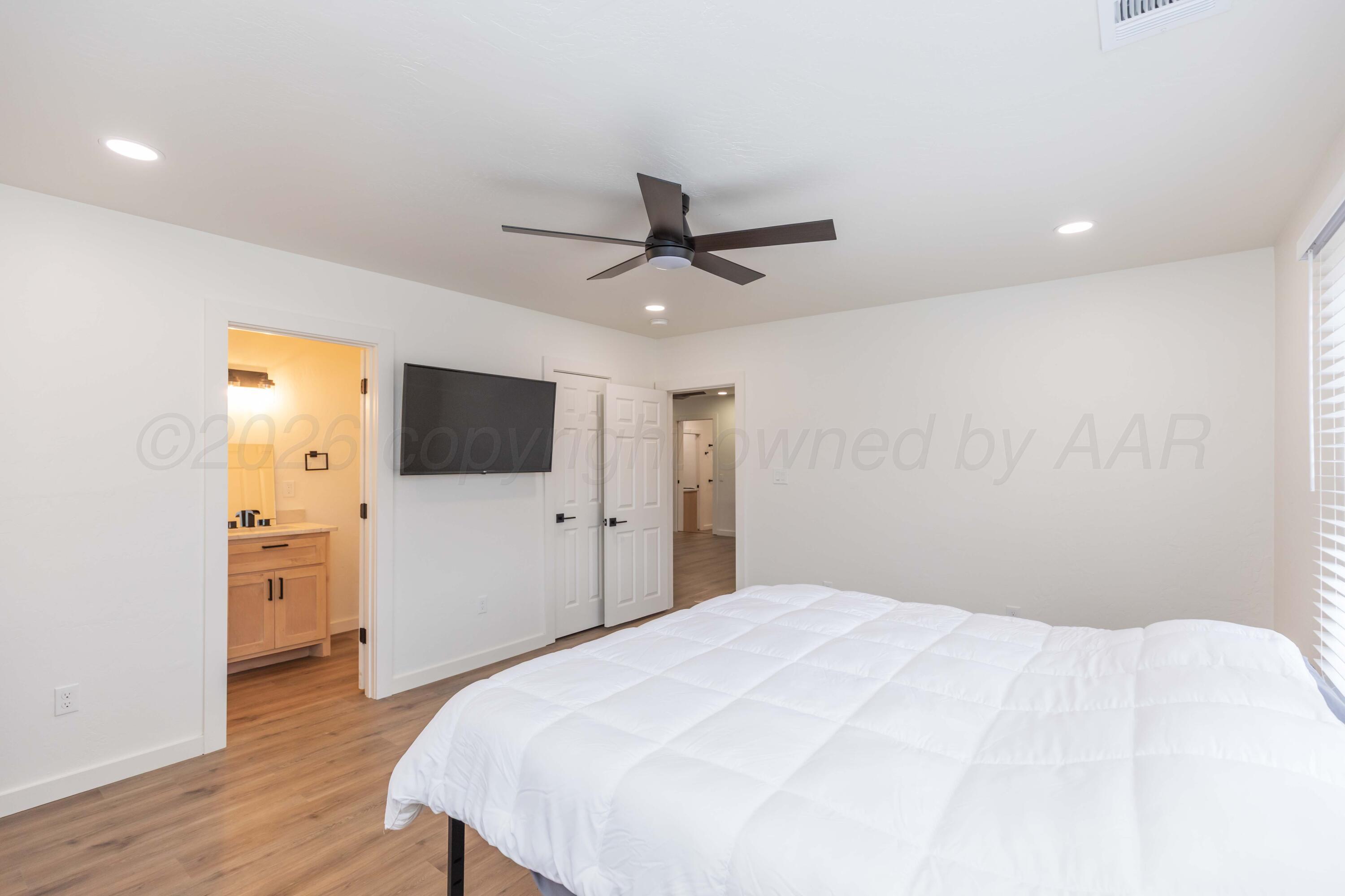504 High Street Claude, TX 79019 - Photo 31 of 39 a bedroom with a bed and a flat screen tv