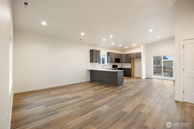 a kitchen with granite countertop a refrigerator stove top oven and sink