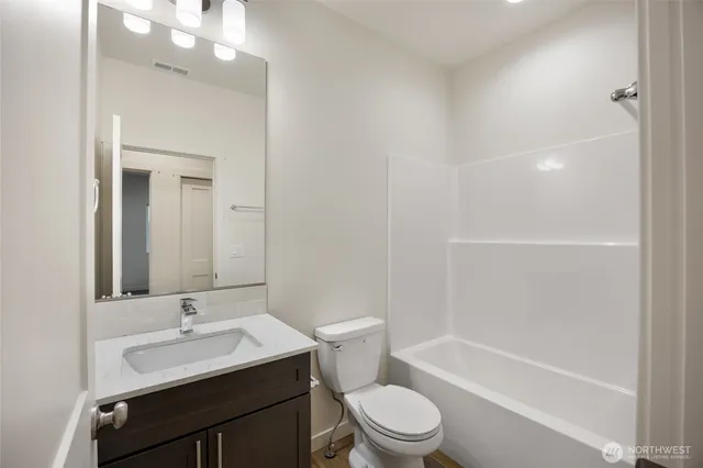 a view of a hallway with wooden floor and cabinet
