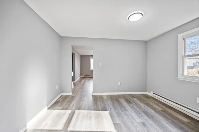 a view of a room with wooden floor and windows