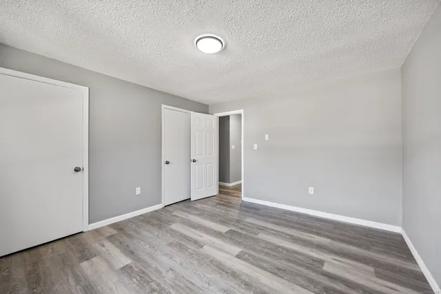 an empty room with wooden floor and closet