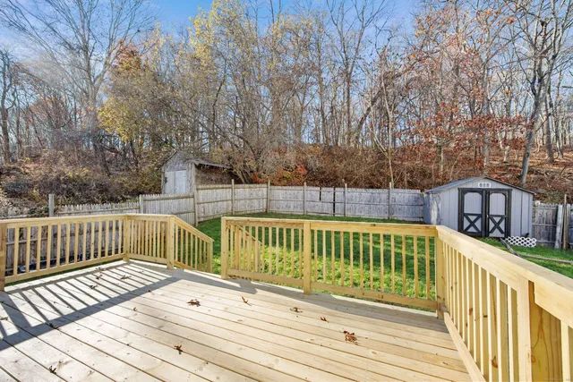a view of a wooden deck with large trees