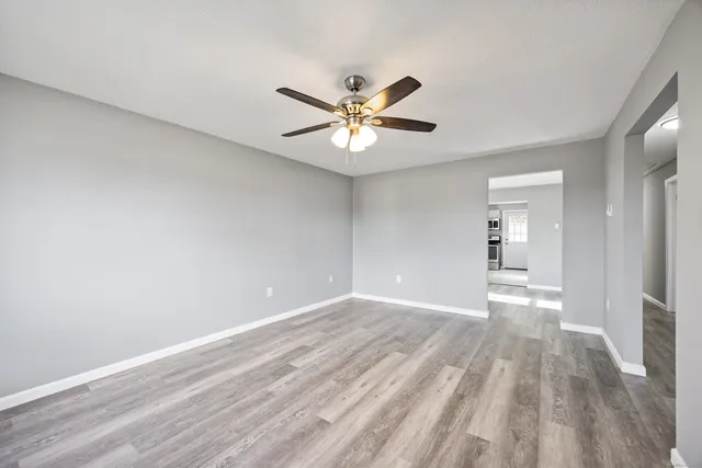 a view of a room with wooden floor and a ceiling fan