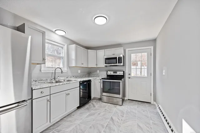 a kitchen with stainless steel appliances granite countertop a refrigerator sink and stove