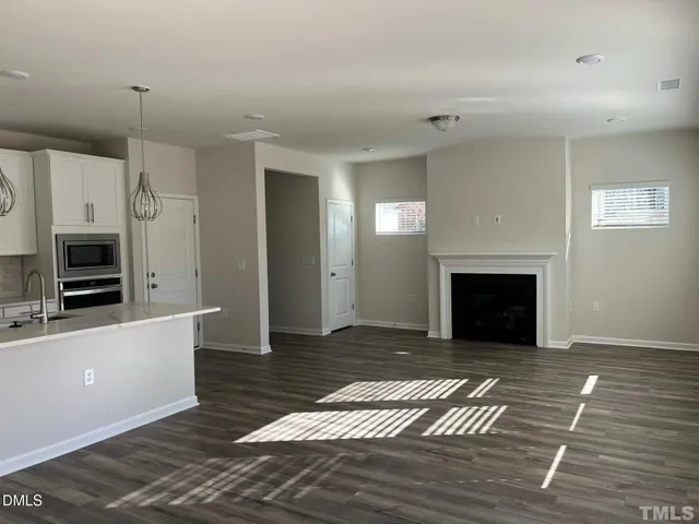 a view of a livingroom with a fireplace wooden floor and staircase