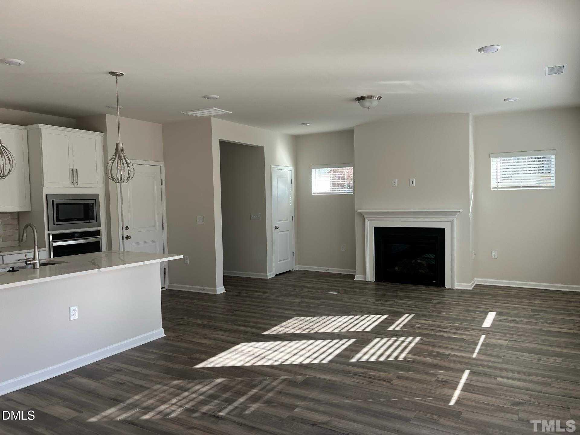 442 Sustainable Way Raleigh, NC 27610 - Photo 2 of 12 a view of a livingroom with a fireplace wooden floor and staircase