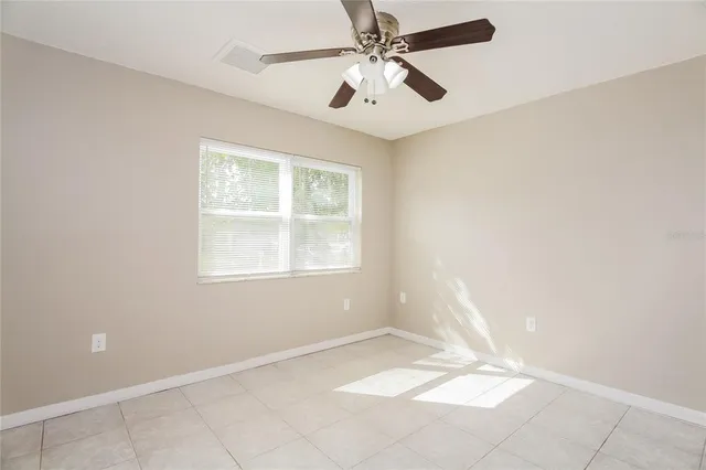 an empty room with a window and a fan