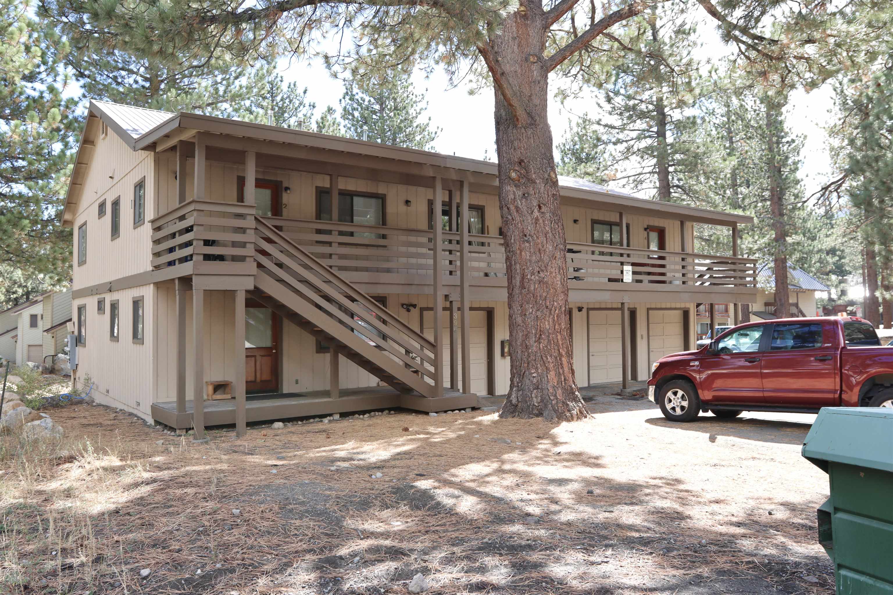 395 Chaparral Road Mammoth Lakes, CA 93546 - Photo 1 of 22 Rustic home with stairway, a metal roof, a deck, driveway, and an attached garage