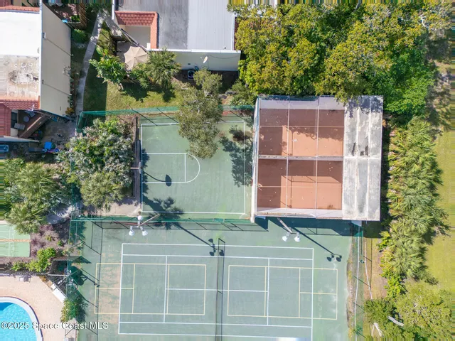 a view of backyard with table and chairs and a large tree