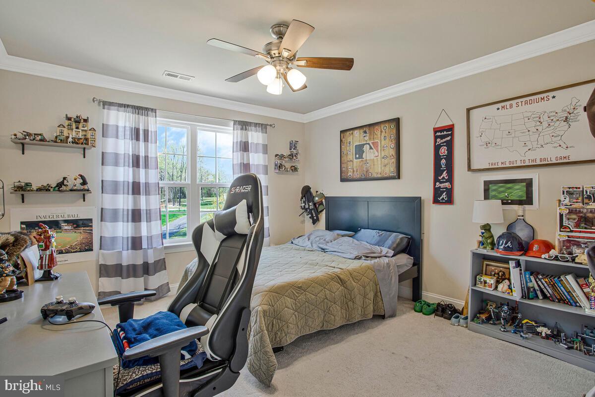 54 Simmons Ridge Road Prince Frederick, MD 20678 - Photo 29 of 55 a bedroom with a bed a large window and book self