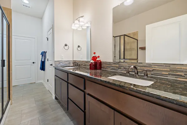 a bathroom with double vanity and a mirror