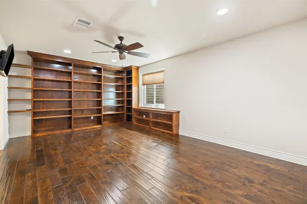 a view of room with wooden floor and ceiling fan
