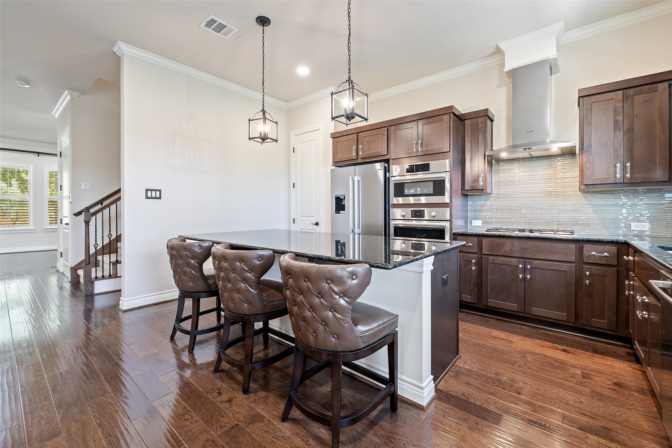 233 Adams Street Georgetown, TX 78628 - Photo 8 of 37 a kitchen with stainless steel appliances granite countertop a stove top oven a refrigerator a sink and chairs