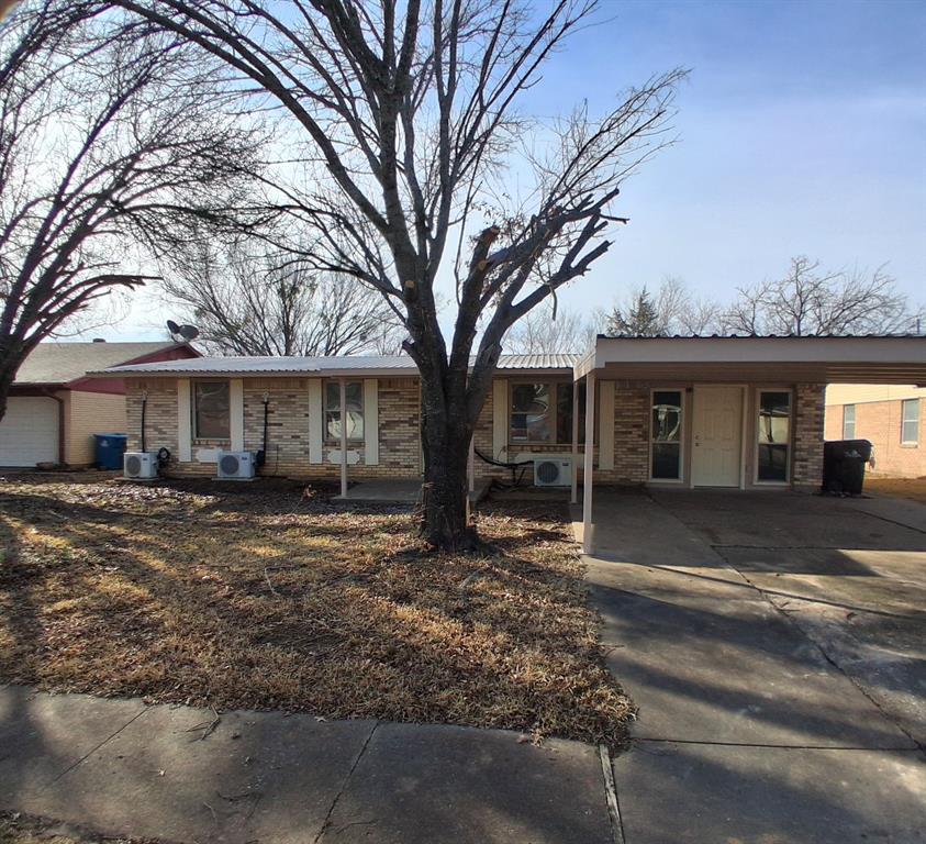 a view of a house with a yard and large tree