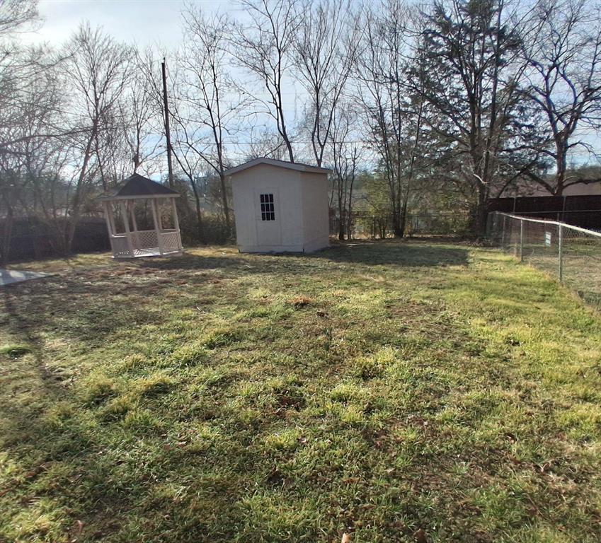 516 Forrest Lane Denison, TX 75021 - Photo 16 of 16 a backyard of a house with large trees and plants