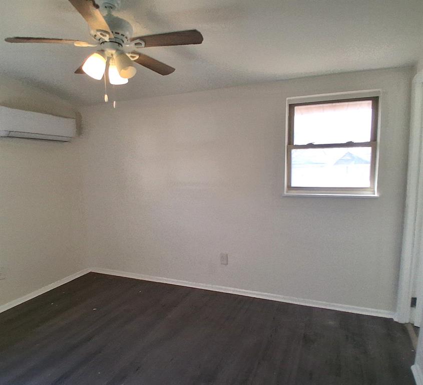 516 Forrest Lane Denison, TX 75021 - Photo 9 of 16 an empty room with wooden floor fan and windows
