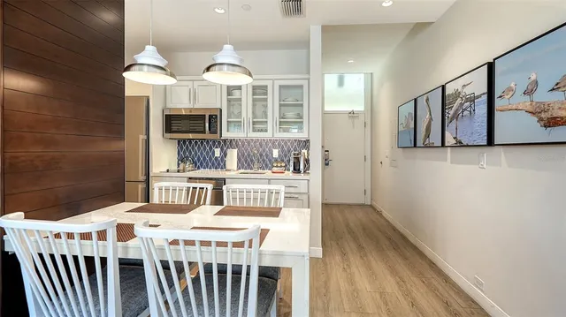 a dining room with wooden floor and furniture