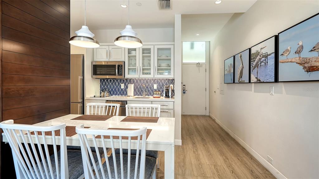 225 Sands Point Road, Unit 6201 Longboat Key, FL 34228 - Photo 12 of 30 a dining room with wooden floor and furniture