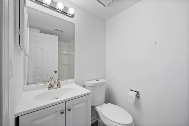 a bathroom with a sink a toilet and a mirror