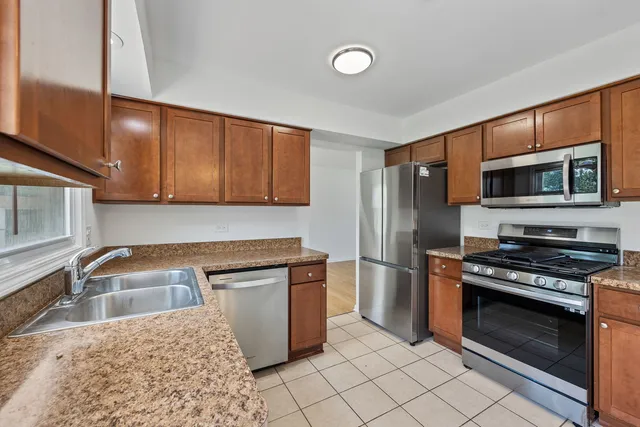 a kitchen with granite countertop a sink and steel appliances