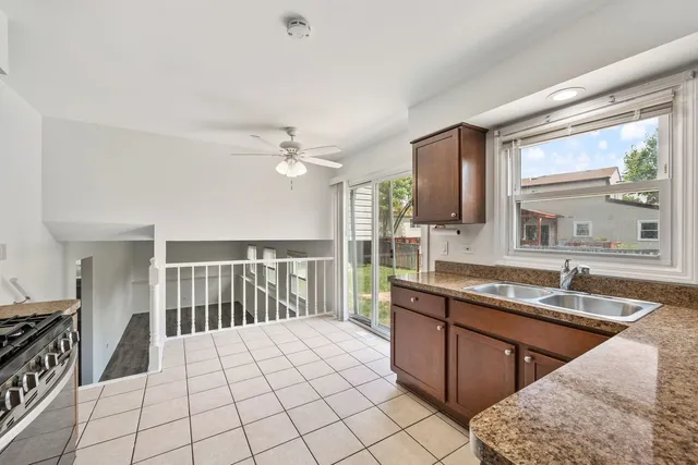a large kitchen with kitchen island granite countertop a sink and a stove top oven