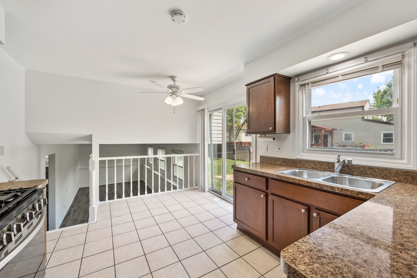 2229 Kensington Drive Schaumburg, IL 60169 - Photo 4 of 14 a large kitchen with kitchen island granite countertop a sink and a stove top oven