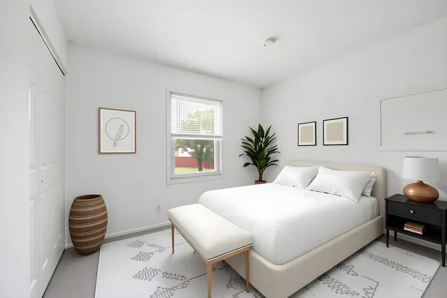 a bedroom with bed and a potted plant