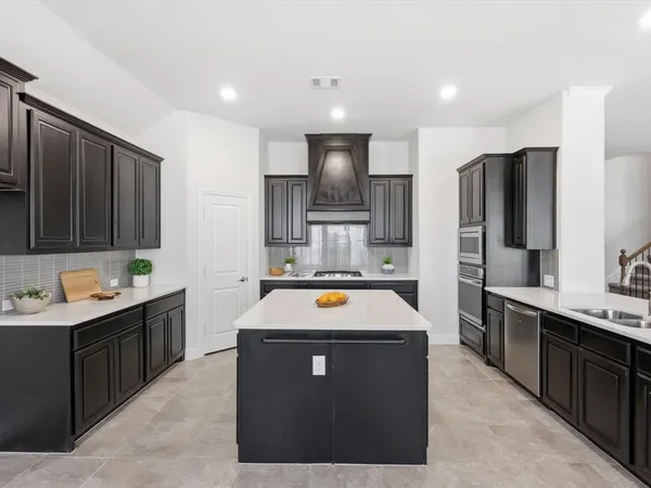 a view of a kitchen with stainless steel appliances kitchen island a sink stove and refrigerator