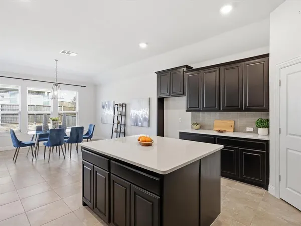 a kitchen with a sink a stove and chairs