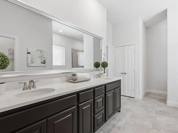a bathroom with a granite countertop sink two large mirror and cabinets