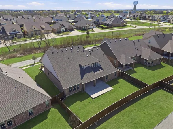 an aerial view of a residential houses with outdoor space and a lake view