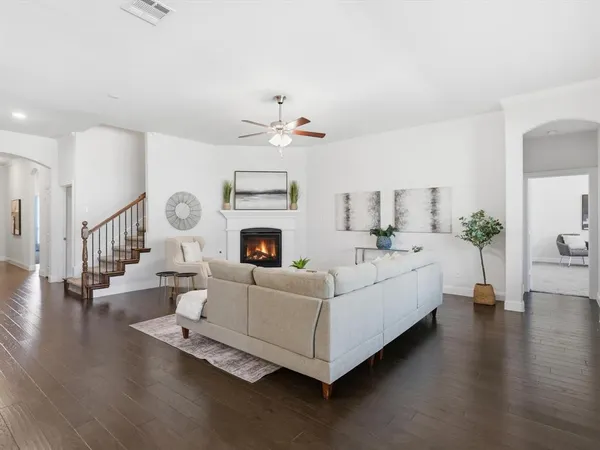 a living room with furniture a fireplace and a chandelier