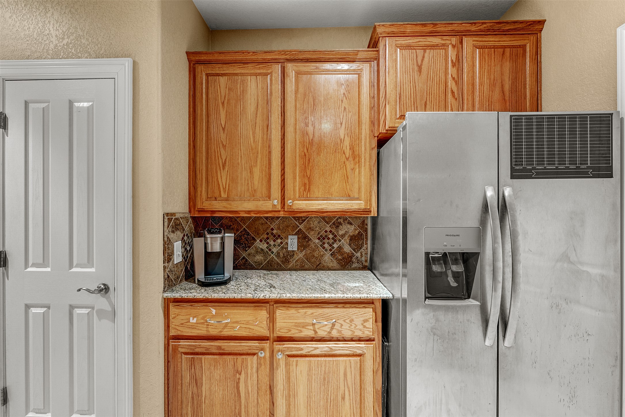 100 Magan Lane Jarrell, TX 76537 - Photo 12 of 31 a kitchen with a refrigerator and cabinets