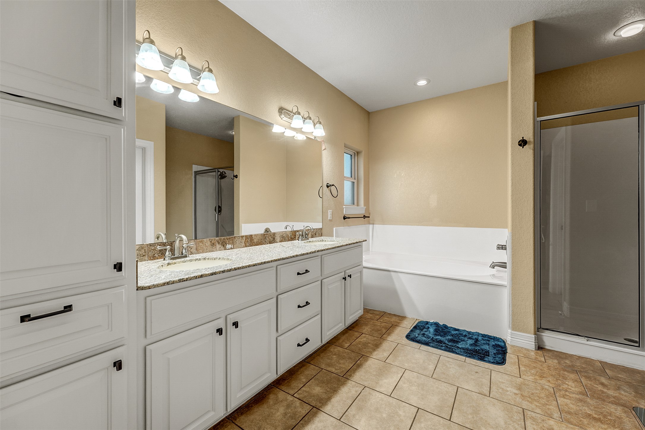 100 Magan Lane Jarrell, TX 76537 - Photo 19 of 32 a spacious bathroom with a double vanity sink a mirror and a bathtub