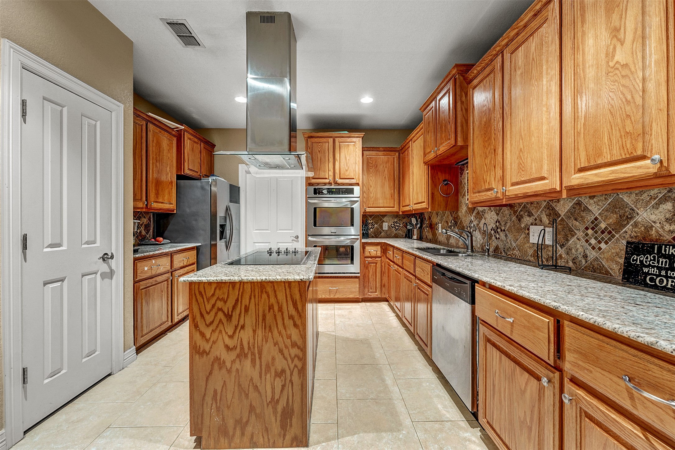 100 Magan Lane Jarrell, TX 76537 - Photo 9 of 31 a kitchen with stainless steel appliances granite countertop a refrigerator a oven a sink with island and chairs
