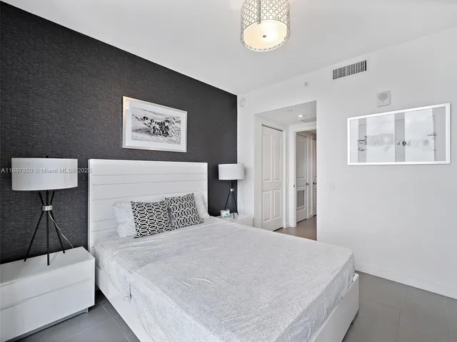 a bedroom with a bed and a lamp