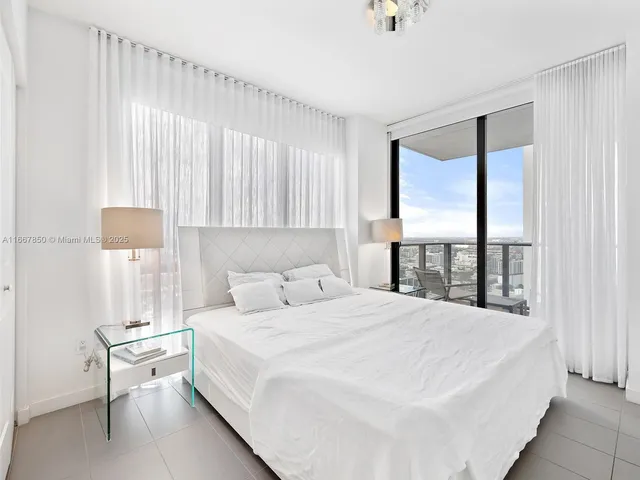 a bedroom with a bed and a large window