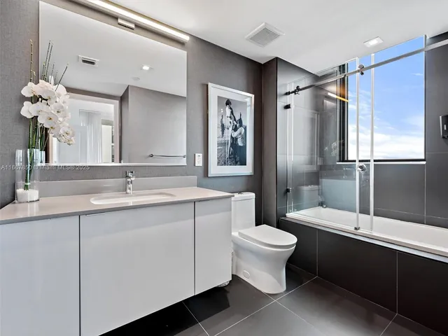 a bathroom with a double vanity sink mirror and toilet