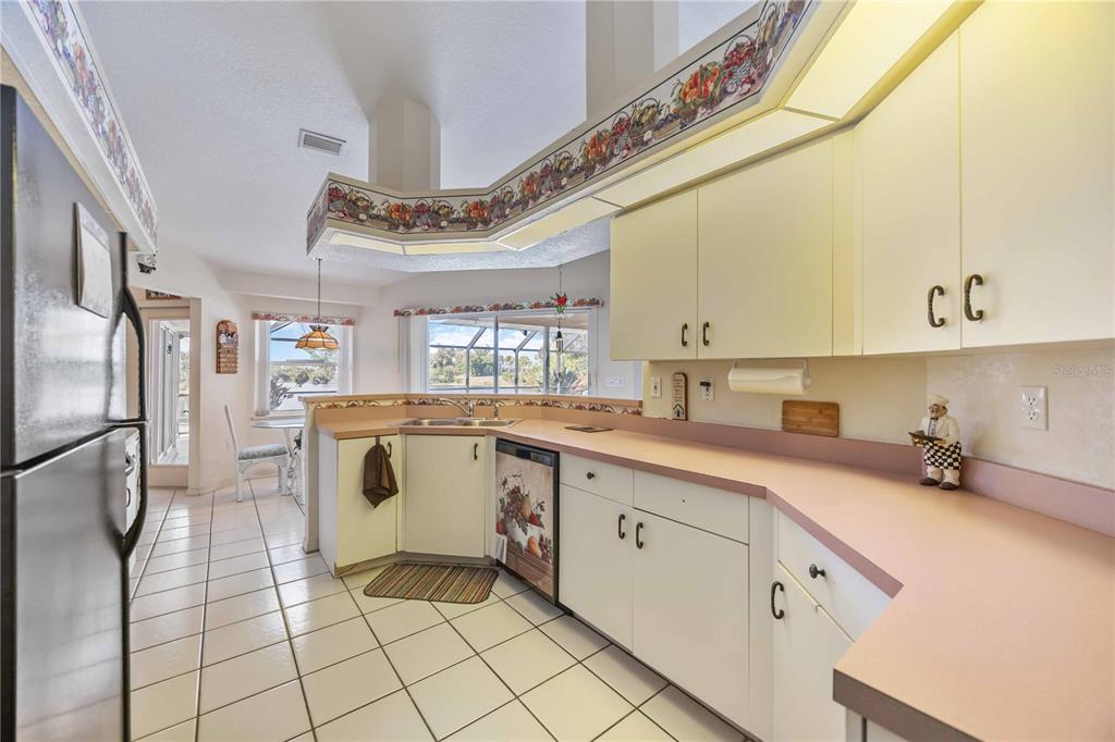 222 Sportsman Road Rotonda West, FL 33947 - Photo 16 of 54 a kitchen with a sink a refrigerator and cabinets