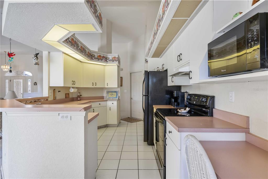 222 Sportsman Road Rotonda West, FL 33947 - Photo 18 of 54 a kitchen that has a sink a microwave a refrigerator and a stove