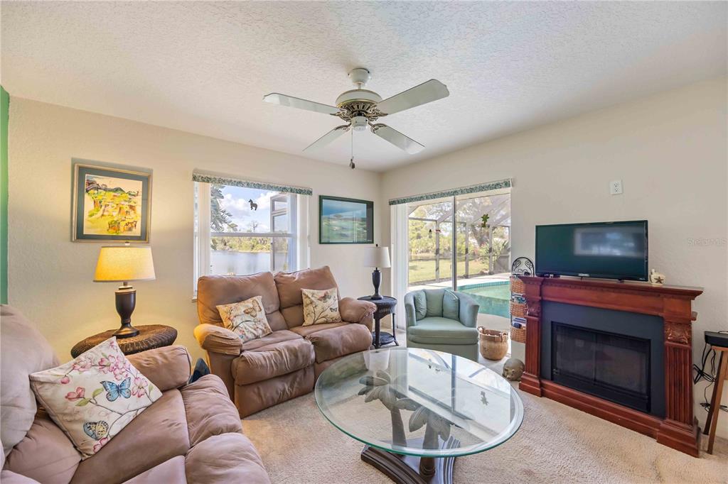 222 Sportsman Road Rotonda West, FL 33947 - Photo 28 of 54 a living room with furniture a flat screen tv and a fireplace