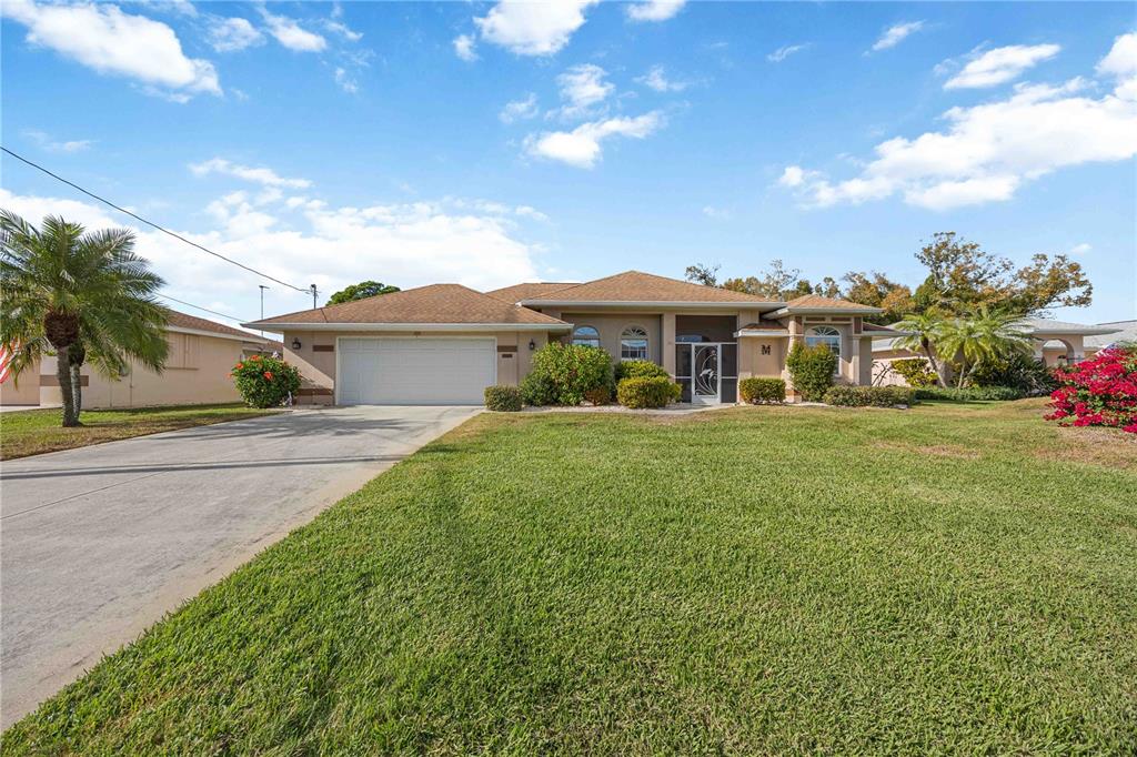 222 Sportsman Road Rotonda West, FL 33947 - Photo 40 of 54 a front view of a house with a garden and yard