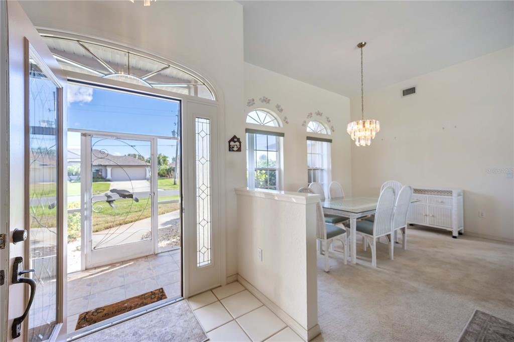 222 Sportsman Road Rotonda West, FL 33947 - Photo 10 of 54 a view of a dining room with furniture large windows and wooden floor