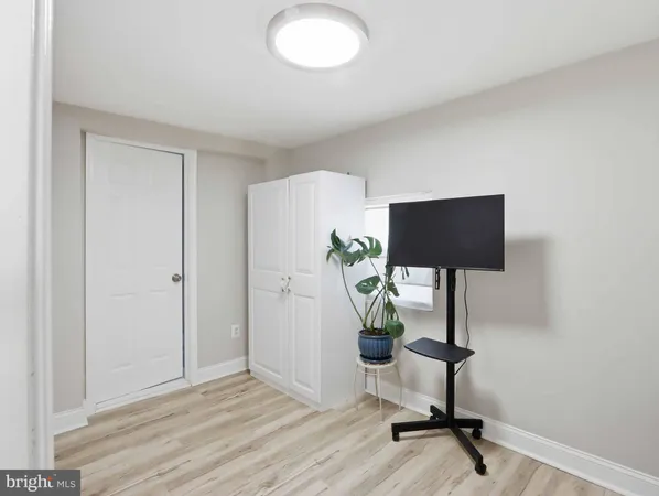 a view of a workspace room with hardwood floor and a ceiling fan