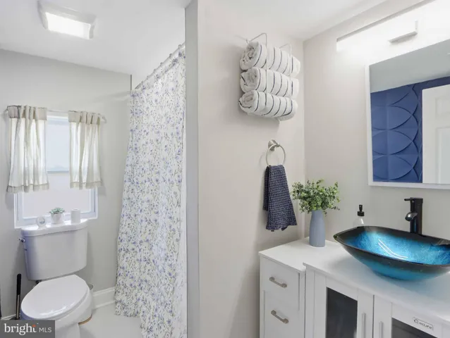 a bathroom with a granite countertop sink a toilet and a shower