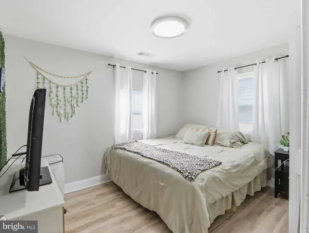 a bedroom with a bed and a flat tv screen on a dresser