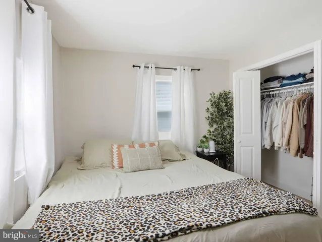 a bedroom with a bed and a refrigerator